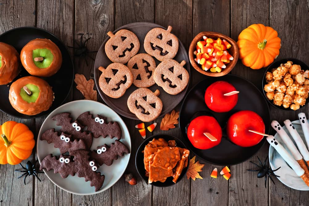 a buffet of Halloween themes sweet treats such as toffee apples and bat and pumpkin shaped 